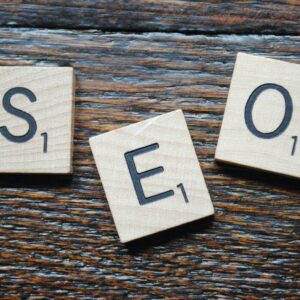 Close-up of Scrabble tiles spelling SEO on a wooden table for content strategy.